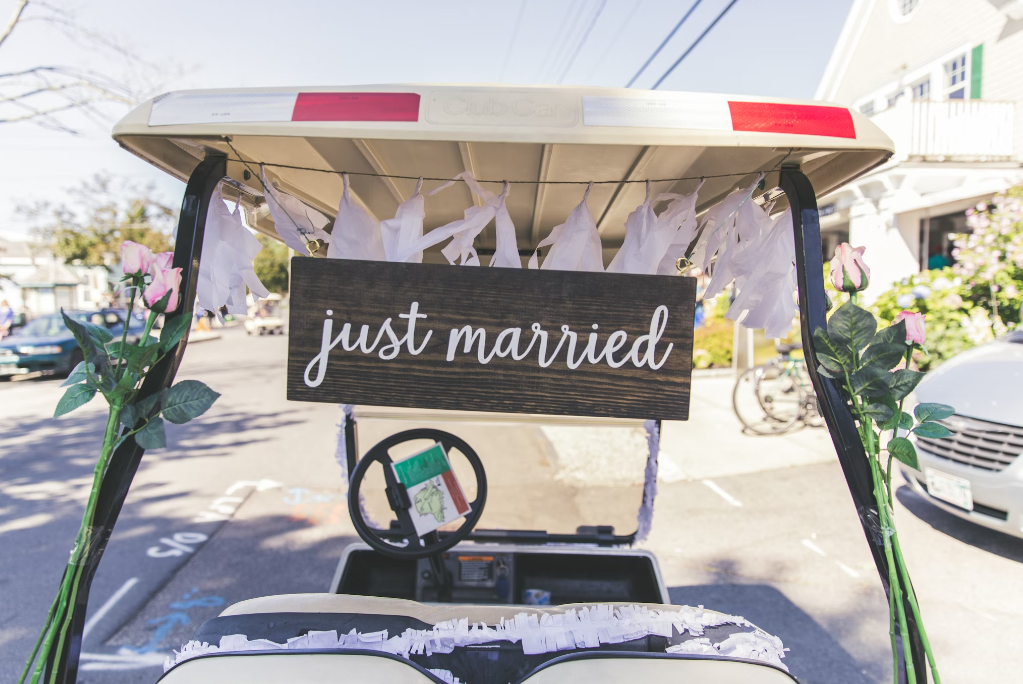 A couple using a golf cart as a post-wedding ride.