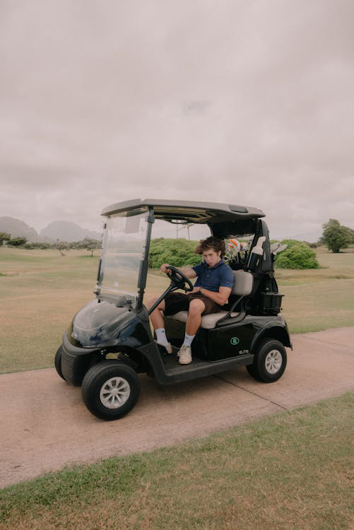 A young person in an eco-friendly golf cart on the fairway