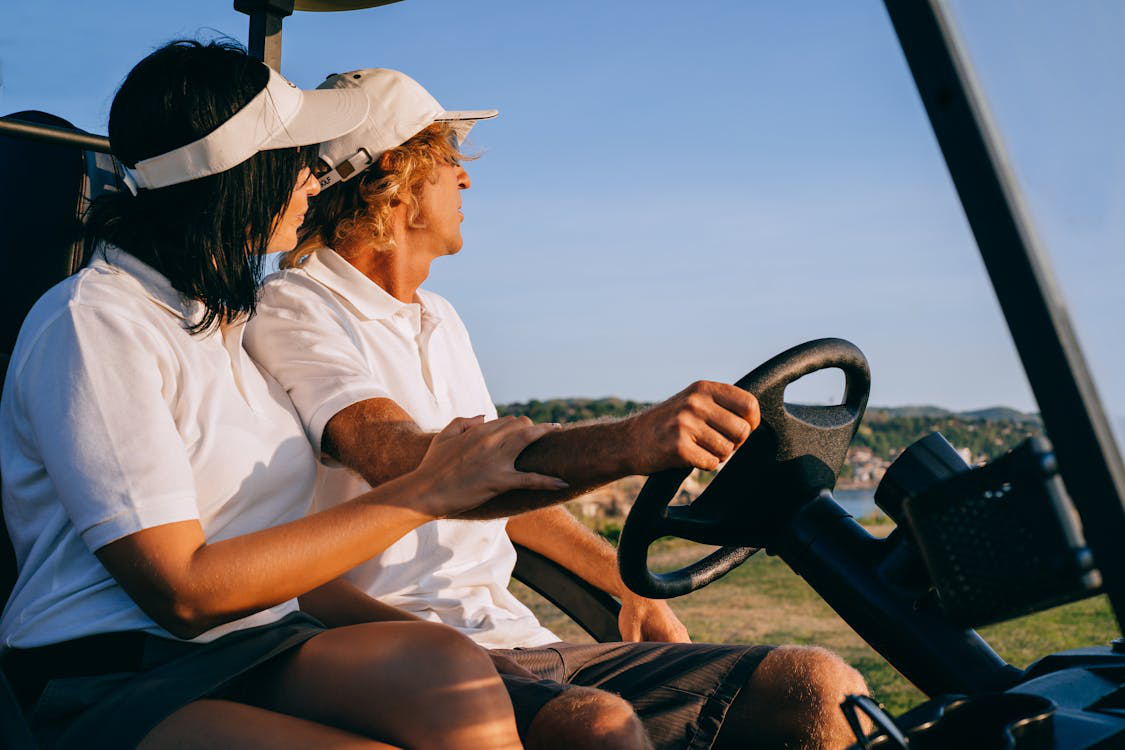 A couple driving in a golf cart looking at the view