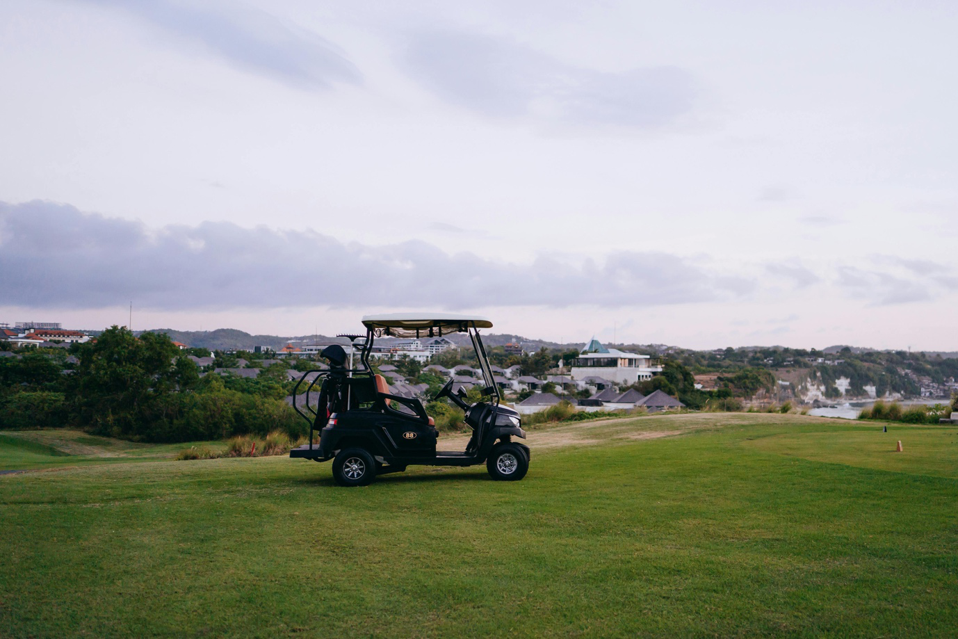 Black golf cart with safety upgrades on the course